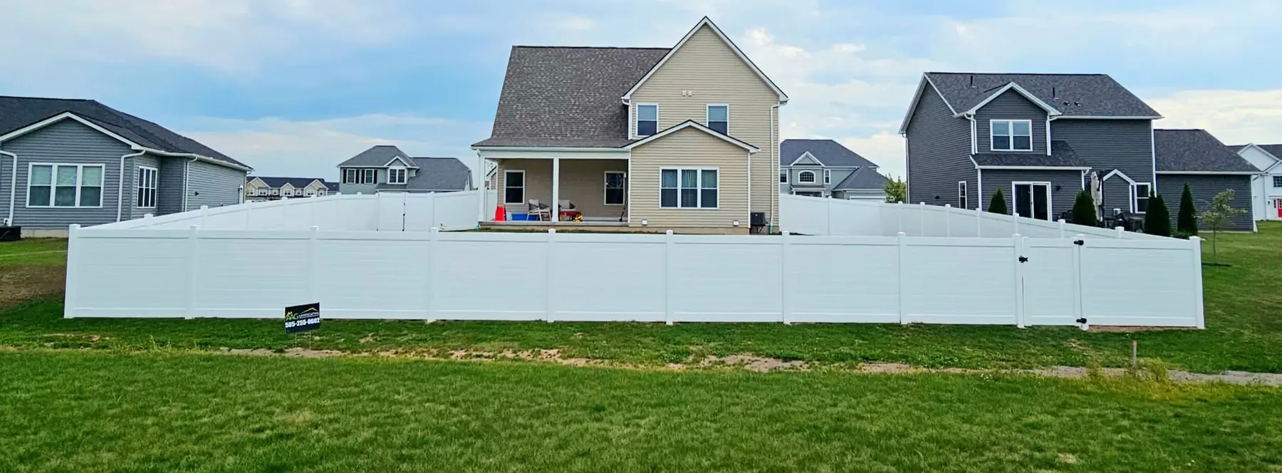Finished white vinyl privacy fence enclosing a backyard